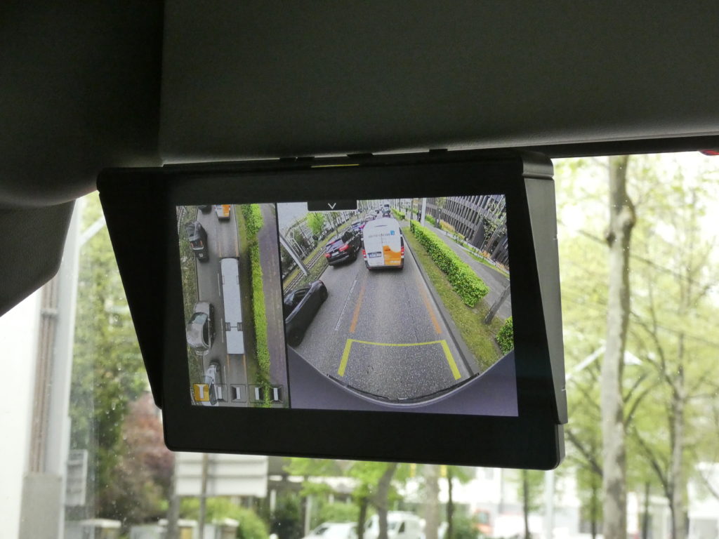 Der geteilte Bildschirm zeigt den Bus aus der Vogelperspektive und zugleich eine weitere Verkehrssituation.